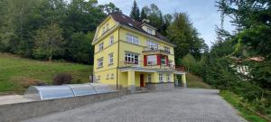 una casa amarilla en la cima de una colina en Villa Weber Apartments, en Albrechtice v Jizerských horách 97 fotos más