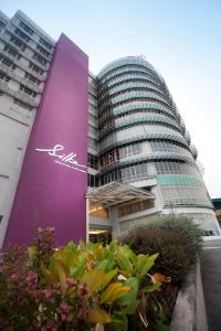 Un edificio alto con un letrero púrpura. en Silka Cheras Kuala Lumpur, en Kuala Lumpur
