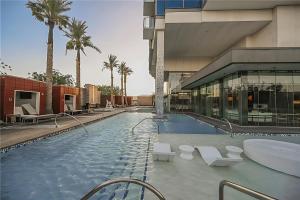 拉斯维加斯Palms Place Hotel StripView with Open Balcony -33的棕榈树建筑中的一个大型游泳池