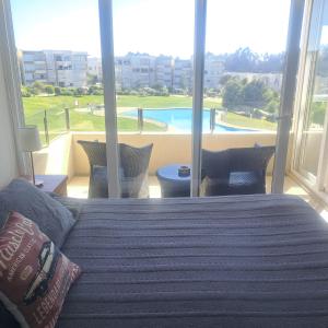 a bedroom with a bed and a view of a pool at Lomas de Papudo 4 in Agua Salada
