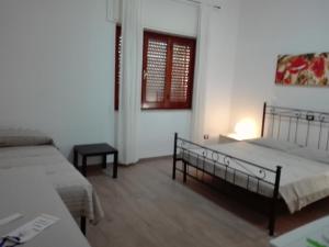 a bedroom with two beds and a table and a window at B & B La Magnolia in Specchiolla