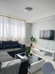 a living room with a couch and a table at Osheni City Center Apartment in Windhoek +13 photos