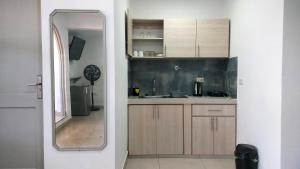 a kitchen with wooden cabinets and a mirror at ASTRO Apartamento Privado - Precio al Cambio Oficial in Tarija