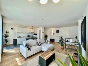 a large living room with a couch and a kitchen at L'Urban chic in Annemasse