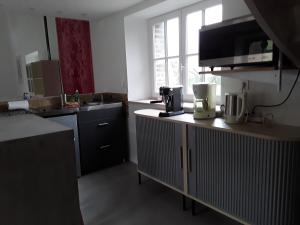 a kitchen with a sink and a counter top at Gîte La Cour Cachée in Saulx-en-Woëvre