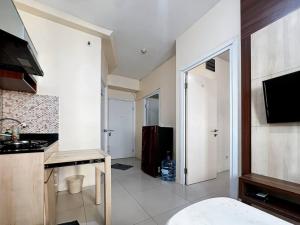 雅加达2BR Apt Green Pramuka with Pool & Wi-Fi by 2ndHome的客房设有带水槽和炉灶的厨房