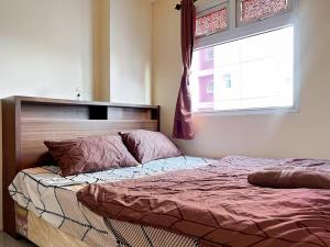 雅加达2BR Apt Green Pramuka with Pool & Wi-Fi by 2ndHome的带窗户的卧室里的一张床 更多14张照片