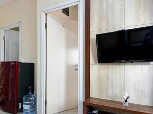Televiisor ja/või meelelahutuskeskus majutusasutuses 2BR Apt Green Pramuka with Pool & Wi-Fi by 2ndHome