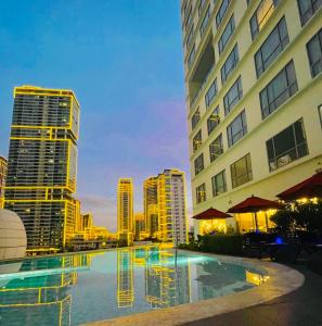 una piscina en una ciudad con edificios altos en The Hotel at Tower Acqua 1, en Manila