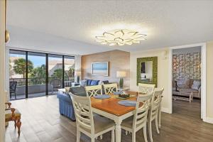 a dining room and living room with a table and chairs at 6415 Midnight Pass #202 in Siesta Key
