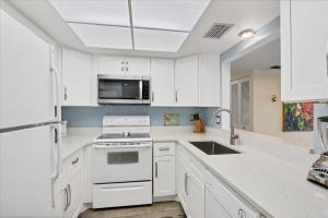 a white kitchen with a sink and a stove at 6415 Midnight Pass #202 in Siesta Key +55 photos