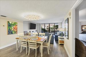 a dining room and living room with a table and chairs at 6415 Midnight Pass #202 in Siesta Key