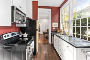 a kitchen with white cabinets and a black refrigerator at 1864 Little Brick - 1 Bed, 1 Bath, Full Kitchen, Pet Friendly with fee, Washer & Dryer in Natchez +17 photos