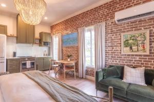 a living room with a couch and a brick wall at Natchez Charm - Studio, 1 Bath, Full Kitchen, King Bed, 2 Blocks from Mississippi River in Natchez