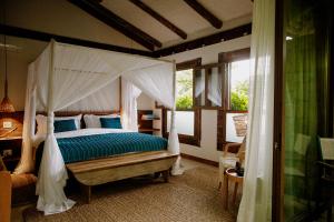 a bedroom with a canopy bed and a window at Casa Salga in Ilhabela