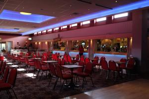 a restaurant with red chairs and tables and a bar at Hoburne park Bluebell10 in Burton