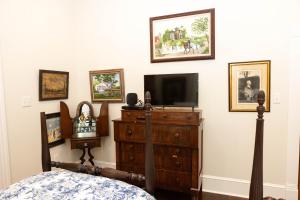 a bedroom with a tv and a dresser with a television at The Dollhouse - 3 Bed, 2 Bath, Walk to Downtown in Natchez
