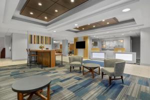 a waiting room with chairs and tables and a tv at Holiday Inn Express Hotel & Suites West Coxsackie by IHG in West Coxsackie