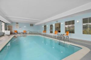 a large swimming pool with chairs and a table at Holiday Inn Express Hotel & Suites West Coxsackie by IHG in West Coxsackie