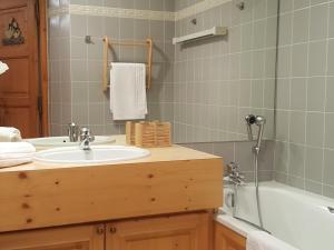 a bathroom with a sink and a bath tub at Courchevel: Skis aux pieds, 3 ch, Wifi, Parking, 4 pers - FR-1-575-24 in Courchevel