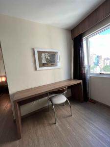 a room with a desk with a chair and a window at LK Barro Preto 8 in Belo Horizonte