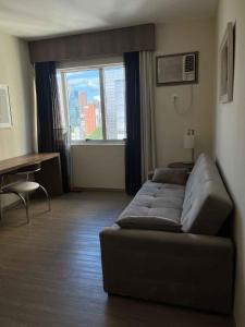 a living room with a couch in front of a window at LK Barro Preto 8 in Belo Horizonte