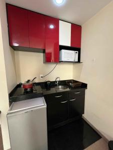 a small kitchen with red cabinets and a sink at LK Barro Preto 8 in Belo Horizonte +17 photos