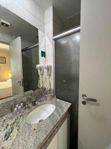 a bathroom with a sink and a mirror at LK Barro Preto 8 in Belo Horizonte