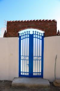 una puerta azul al lado de una valla blanca en Karma house, en Luxor