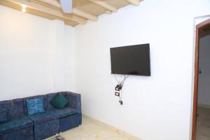 Una sala de estar con un sofá y un televisor en una pared. en Karma house, en Luxor