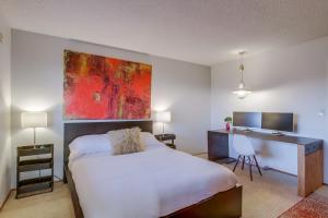 a bedroom with a bed with a desk and a painting at Red Hawk Coastal Estate in San Diego