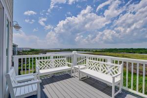 a balcony with two white benches on a white fence at Sea Haven by Sea Scape Properties in North Topsail Beach