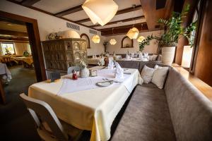 a dining room with a table and couches in a restaurant at Hotel Spessartstuben in Haibach