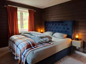 a bedroom with a bed with a blue headboard and a window at Libeli Panorama in Lona +31 photos