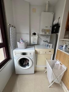 a laundry room with a washing machine and a washer at Avanza 4 Plaza Galicia in Sarria