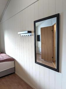 a mirror on the wall of a room with a bedroom at Haugesund City Apartments in Haugesund