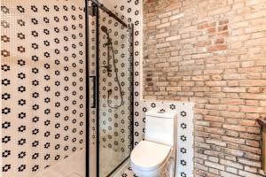 een badkamer met een toilet en een bakstenen muur bij North House - Bohemian Vieux Quebec Two Bedroom in Québec +19 foto's