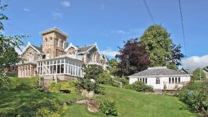 a large house on a hill with a yard at Holly Lodge in Strathpeffer