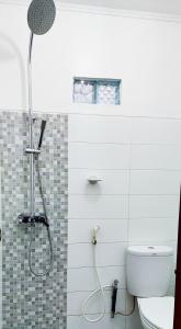 a bathroom with a shower and a toilet at Sarwi Endah Beach Cottage in Tepus