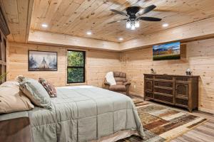a bedroom with a bed and a ceiling fan at Little Bear Lodge, 3BR2BA private cabin in Cosby, TN Gorgeous outdoor space, fire pit, hot tub in Cosby