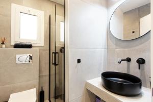 Un baño con un lavabo negro y un espejo. en Mediterranean Bliss, en Sant Adrià de Besòs