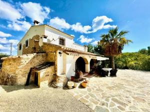 a building with a palm tree in front of it at Casa rural exclusiva con vista al mar en Calpe in Empedrola
