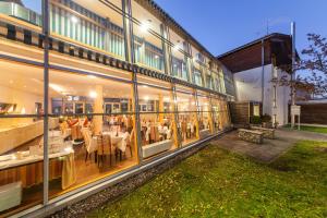 ein Restaurant mit Tischen und Stühlen in einem Gebäude in der Unterkunft Novum Hotel Seidlhof München in Haar