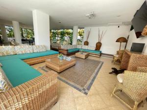 a living room with couches and chairs and a television at Zahira Hotel Melgar in Melgar