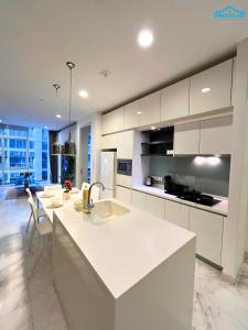Una cocina con gabinetes blancos y una encimera blanca. en Platinum KLCC 2BR by Dream Inn, en Kuala Lumpur