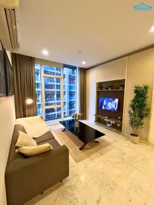 Una gran sala de estar con un sofá y un televisor. en Platinum KLCC 2BR by Dream Inn, en Kuala Lumpur