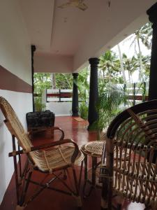 a porch with two chairs and a table at Shoreline Marari Beach Villa At Golden Beach Mararikulam in Alleppey