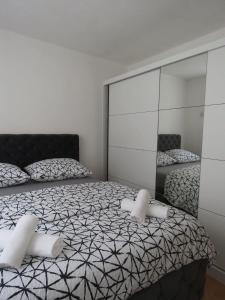 a bedroom with two beds and a large mirror at Apartman City in Jajce