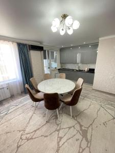 a dining room with a table and chairs at Просторная квартира 3 х ком в Новом районе in Shymkent