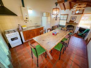 a large kitchen with a wooden table and chairs at Chawasi Cabañas in Campo Quijano